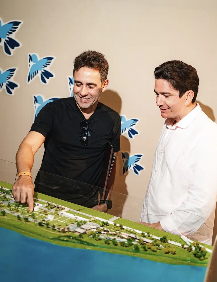 Clientes escolhendo o lote na maquete do loteamento