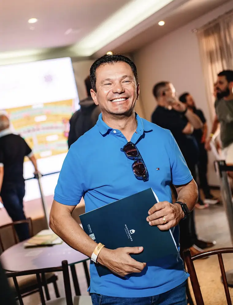 Cliente com o book do Vila dos Pássaros depois de escolher o lote